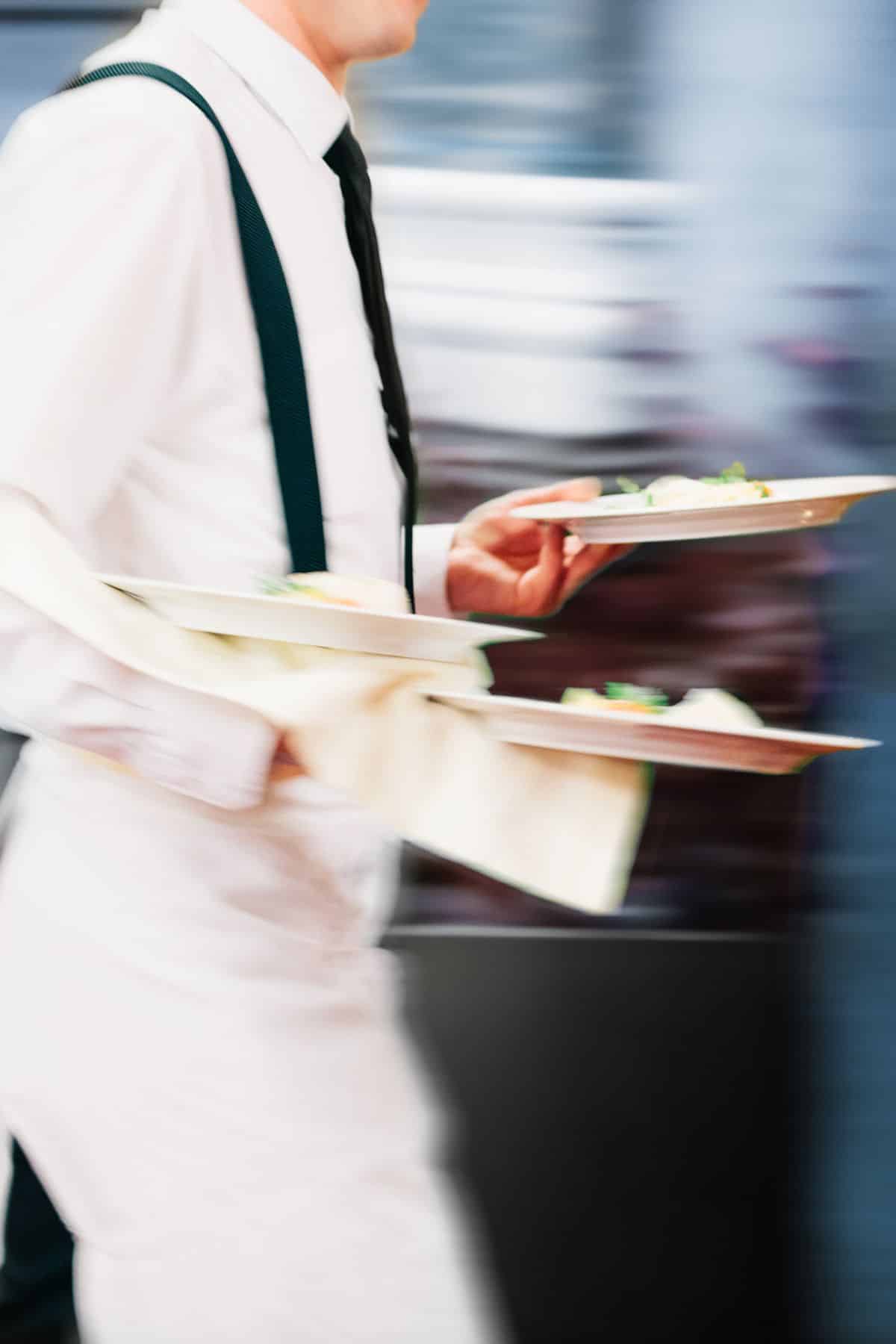 waiter delivering food at a restuarant in Italy